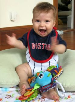 Darwin clapping her hands, wearing a Red Sox uniform and bib