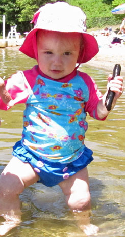 Darwin wading in the water, carrying a small stick
