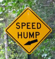 A diamond-shaped 'SPEED HUMP' sign