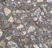 A section of asphalt pavement with embedded pebbles